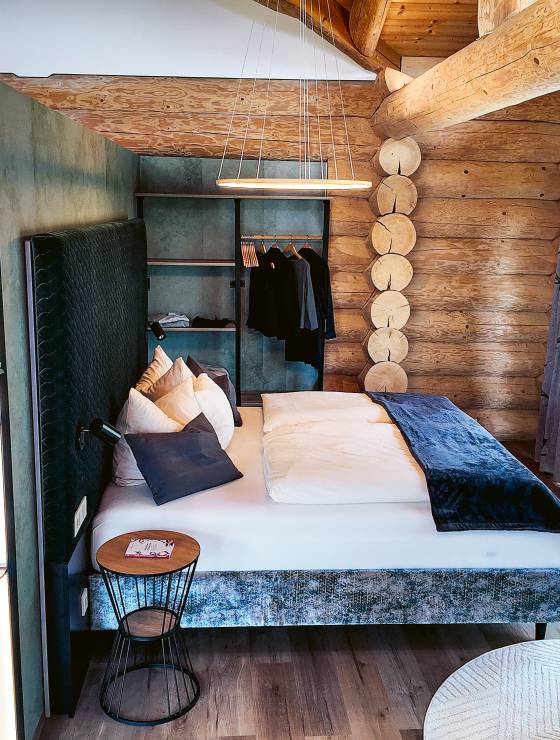 Offenes Raumkonzept in einem Chalet mit Doppelbett und begehbarer Dusche
