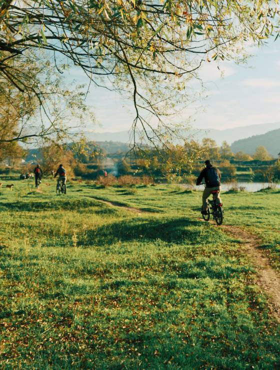 Radfahrer entlang eines Flusses im Herbst